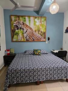 a bedroom with a bed and a painting on the wall at LoftJaguar in Palenque
