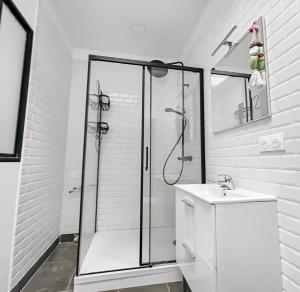 a white bathroom with a shower and a sink at La maison peinte par Eugene Delacroix - Netflix in Cambrai +17 photos