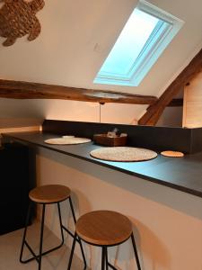 a kitchen with a counter with stools and a skylight at Suite Spa Cinta in Trie-Château +11 photos