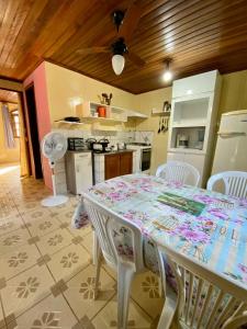 a kitchen with a table and chairs in a room at Kitinete da Cris in Ilha do Mel