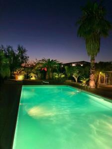 a large blue swimming pool at night at The Bamboo villa in Casale la Cogna
