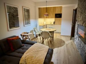 a living room with a couch and a table and a kitchen at Kamzík 51 Donovaly in Donovaly