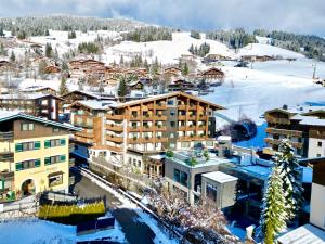 a town in the snow with snow covered buildings at Hotel Kendler in Saalbach-Hinterglemm