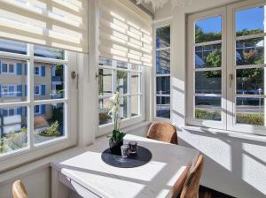 a room with windows and a table and chairs at Brise Villa Emmi App 03 in Heringsdorf