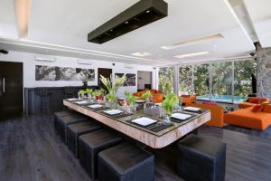 a dining room with a long table and leather chairs at Endless Memories for Large Groups in Private Jungle Retreat in Tanah Lot