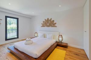 a bedroom with a large white bed with two lamps at Quinta View Apartment, By Home Match in Setúbal