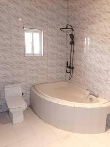 Cutting Edge Guest House في Daranka: حمام أبيض مع حوض ومرحاض