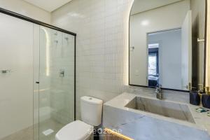 a bathroom with a sink and a toilet and a shower at Acomodações modernas e completas no centro turístico de Gramado - CBGs in Gramado