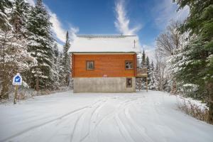 a wooden house in the snow with trees at Chalet Aigle 7 min to SPA for 16 Guests , Skiing in Saint-Paul-de-Montminy