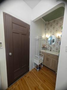 a bathroom with a sink and a brown door at Mai Anh Garden in Soc Trang