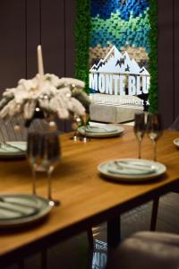 a wooden table with plates and wine glasses on it at Monte Blu in Migovo