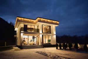 a large house with lights on it at night at Monte Blu in Migovo +15 photos
