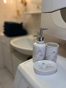 Una botella blanca de jabón y una taza sobre un mostrador. en Apartment with garage and garden, 