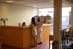 two women standing at a counter in a office at Vilaró Art Wine Hotel in Buenos Aires
