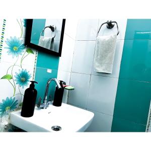 une salle de bains avec un lavabo et un miroir dans l'établissement Family & Couples Studio Kitchen, 2 King Beds, à Dehradun