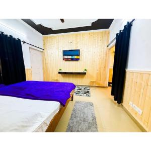 une chambre avec deux lits et une télévision au mur dans l'établissement Family & Couples Studio Kitchen, 2 King Beds, à Dehradun