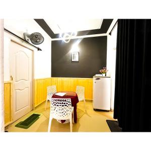 une cuisine avec une table, des chaises et un réfrigérateur dans l'établissement Family & Couples Studio Kitchen, 2 King Beds, à Dehradun 9 autres photos