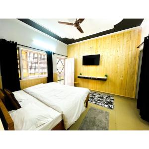 une chambre avec deux lits et une télévision à écran plat dans l'établissement Family & Couples Studio Kitchen, 2 King Beds, à Dehradun