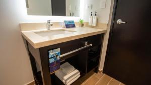 um banheiro com pia, espelho e toalhas em Comfort Inn Tegucigalpa em Tegucigalpa mais 15 fotografias