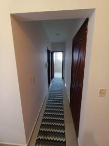 a hallway with black and white stripes on the floor at Apartamento Centro à 100 metros da Praça da Matriz in Boituva