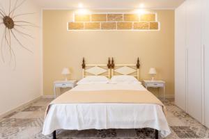 玛丽娜迪曼卡维萨A Pochi Metri Dal Mare Seminterrato的一间卧室配有一张大床和两张桌子