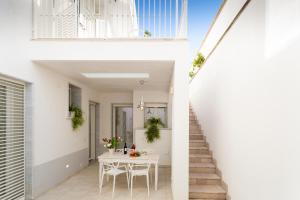 玛丽娜迪曼卡维萨A Pochi Metri Dal Mare Seminterrato的一栋白色的房子，里面有一张白色的桌子和楼梯。