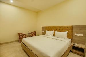 a bedroom with a large bed with white sheets at Hotel Melano Ambala Chandigarh Rd Zirakpur SkyJumper park in Zirakpur +41 photos