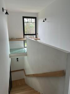 a staircase in a house with a window at Villa Lombardière in Gujan-Mestras