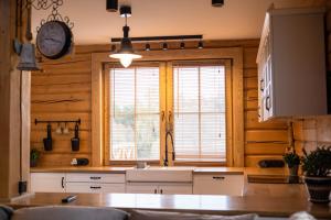 una cucina con un lavandino e un orologio a parete di U Henia a Potrzanowo Altre 115 foto