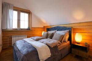 una camera da letto con un letto con una lampada e una finestra di U Henia a Potrzanowo