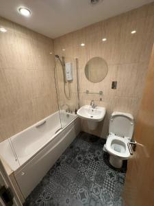a bathroom with a tub and a toilet and a sink at The Athenaeum in Sunderland
