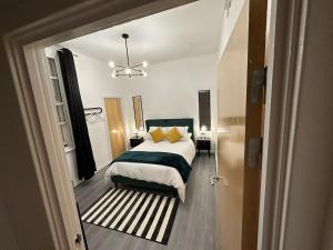 a bedroom with a bed with yellow pillows at The Athenaeum in Sunderland