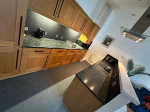 a kitchen with wooden cabinets and a black counter top at The Athenaeum in Sunderland