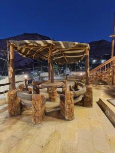 Un pabellón de madera con una mesa en el medio. en Dana Gate Lodge, en Dana