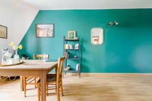 a dining room with a table and a blue wall at Chez Joséphine et Pierre in Cassel
