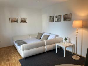 uma sala de estar com um sofá branco e uma mesa em Apartma Tinkara em Bled