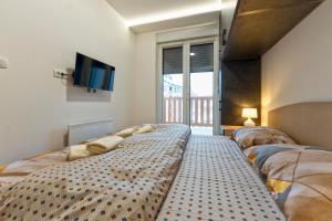 a bedroom with a large bed and a tv at Lux apartman 40 in Zlatibor