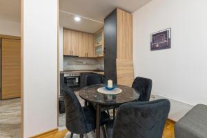 a kitchen and dining room with a table and chairs at Lux apartman 40 in Zlatibor +6 photos