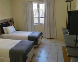 a hotel room with two beds and a television at Vilaró Art Wine Hotel in Buenos Aires +33 photos