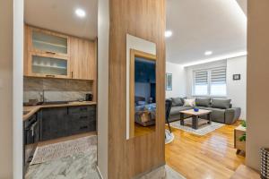 a kitchen and a living room with a couch at Lux apartman 40 in Zlatibor