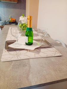 Una botella de vino en una bandeja con dos copas. en Apartman Lipa- Lipovac Bajakovo, en Lipovac 2 fotos más