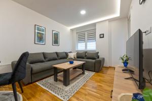 a living room with a couch and a table at Lux apartman 40 in Zlatibor