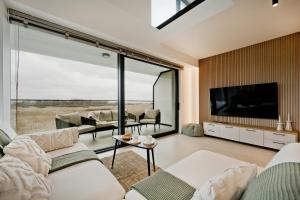 a living room with a large window and a tv at BlueApart Jeżynowa Jastarnia in Jastarnia