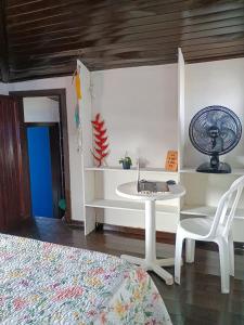 a room with a table and a chair and a fan at Refugio de Mar in Búzios