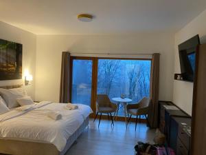 a bedroom with a bed and a table with chairs at Szent László Residence in Mátraszentimre