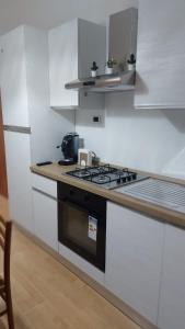 una cucina bianca con fornelli e lavello di Casa Mamus 2 a Pescara Altre 12 foto