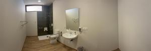 een badkamer met een wastafel, een toilet en een spiegel bij Alojamiento Rural Dilamor in El Picazo