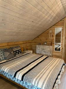 KupiškisSodyba vienkiemyje "Šeimos slėnis"的木屋里有一张床的卧室