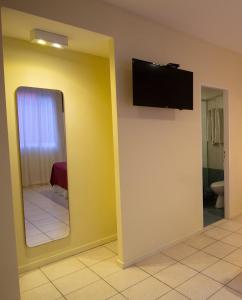a bathroom with a mirror and a tv on the wall at Vilaró Art Wine Hotel in Buenos Aires