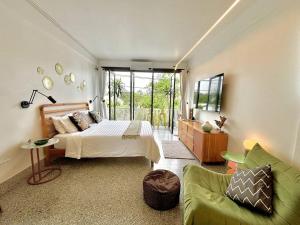 a bedroom with a bed and a green couch at Siri Designer 3-Storey Townhouse with Garden and Luxury Amenities in Bangkok